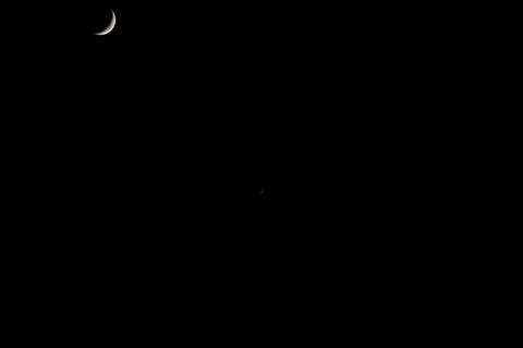 Brightly shining moon in a cloudless night sky Stock Photos