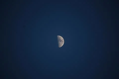 Brightly shining moon in a cloudless night sky Stock Photos