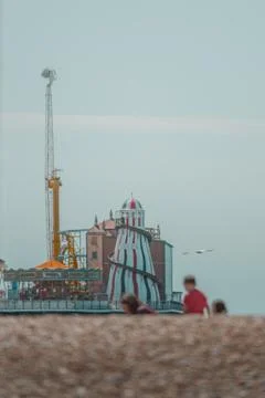 Brighton pier rides in the background behind a family playing on the beach 2020 Stock Photos