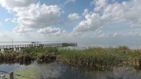 Brilliant blue sky and clouds relect on Lake Apopka at Winter Garden Florida Stock Footage 148423987