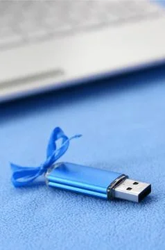 Brilliant blue usb flash memory card with a blue bow lies on a blanket of sof Stock Photos