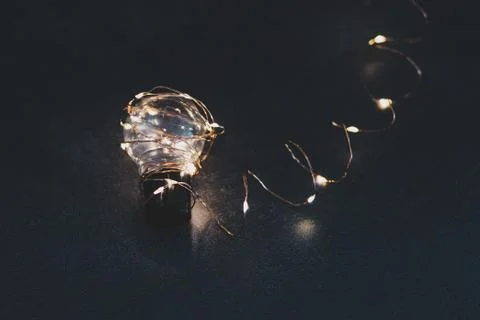 Brilliant creativity, idea lightbulb wrapped up in string lights shining all  Stock Photos
