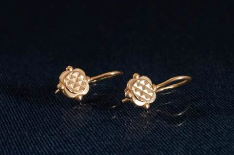 Brilliant earrings from gild on table with reflection Stock Photos