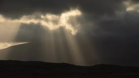 Brilliant sunbeams through clouds over Icelandic mountain valley time lapse 库存影片 118095627