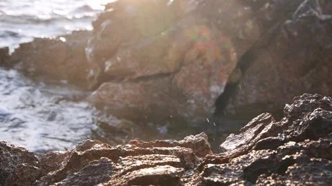 Brilliant sunlight breaks through rocky cliffs along the ocean shore. Stock Footage 337408920