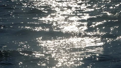 Brilliant sunlight sparkling and reflecting across dark ocean water surface. Stock Footage 337408633