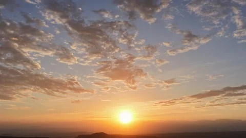 Brilliant Sunrise and Fast Clouds Over Hazy Multi-Layered Southwest Landscape Stock Footage 336696155