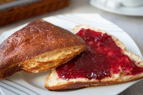 Brined bun with raspberry jam Foto stock