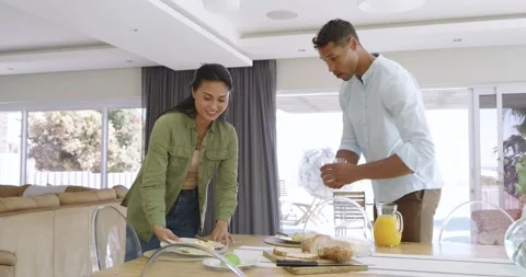 Bringing plates, diverse couple pouring juice and cutting omelette with avocado Stock Footage 335364571