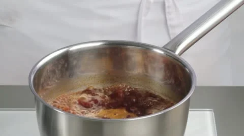 Bringing red wine sauce to the boil Stock Footage 24666289