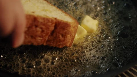 Brioche bread toast is placed in a hot frying pan in slow motion Video stock 150661433