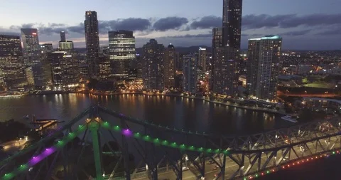 Brisbane night life camera flying down close  to story bridge at sunset aerial Stock Footage 102822292