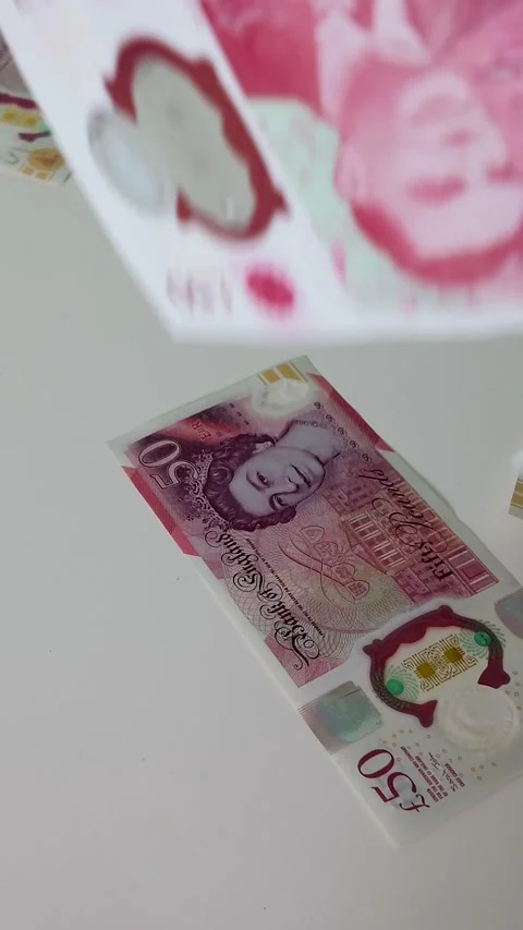 British £50 notes falling at random onto a table surface, 120fps slow motion Stock Footage 334239070
