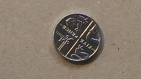 British 5p coin on brown background rotates in front of camera Stock Footage 245832845