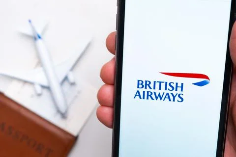 British Airways application on the screen of mobile phone in mans hand. Passport Stock Photos