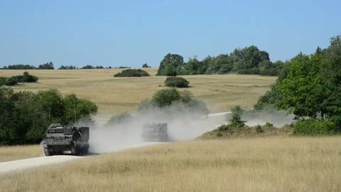 British Army Multiple Launch Rocket Systems travelling along dirt road Stock Footage 201861848