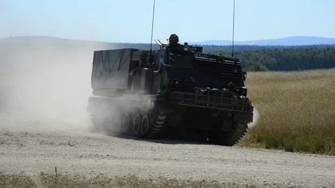 British Army Multiple Launch Rocket Systems travelling over dirt track Видео 201861936