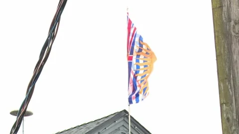 British Columbia Flag Blowing In Wind From Rooftop Stock Footage 154015320