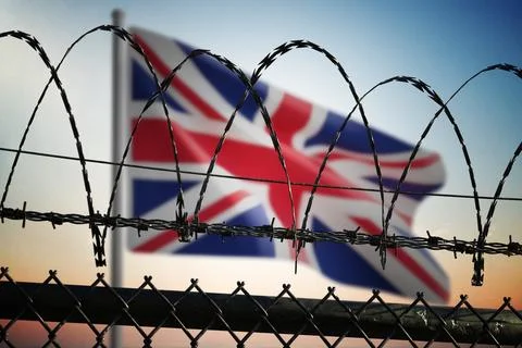 British flag behind barbed wire fence. Illegal immigration and security in Un Stock-Fotos