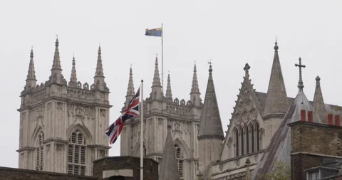 British flag blowing in wind against ornate Gothic church in central London Stock Footage 319792707