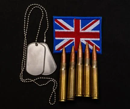 British flag patch with bullets and military dog tags on black background Stock Photos