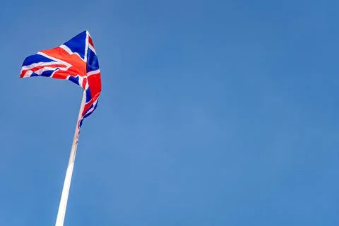 British flag on the top of the pole on blue sky background Stock Photos