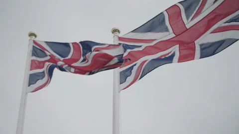 British Flag Union Jack flying in the wind against a cloudy sky. Slow motion 4k Stock Footage 150947427