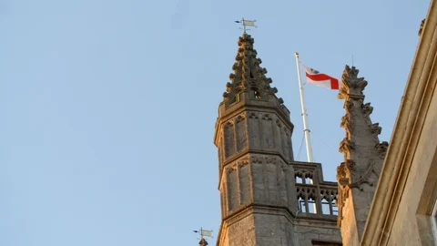 British flag waves on top of cathedral spire at sunset Stock Footage 106781388