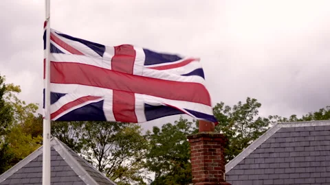 British flag waving over a building on a very windy day Stock Footage 146062228