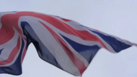 British flag waving in the wind in slow motion with a grey sky as background. Stock Footage 140762977