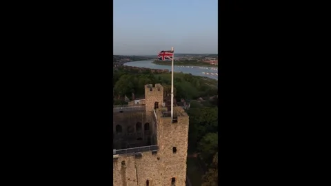 British flag in the wind on Rochester castle at sunrise aerial vertical view Vidéo 336503381