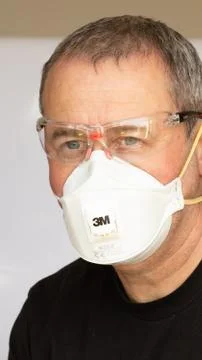 British man wearing protective mask, safety glasses. Isolated on white Stock Photos