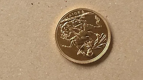 British solid Gold Sovereign coin rotates on brown background Stock Footage 245834204