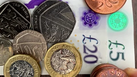 British sterling currency notes and coins with pennies added. Video stock 251011007