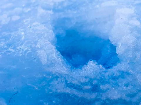 Brittle deep hole in translucent ice Stock Photos