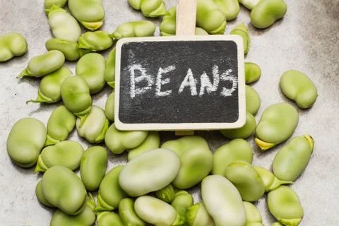 Broad beans on a marble table with a sign Stock Photos