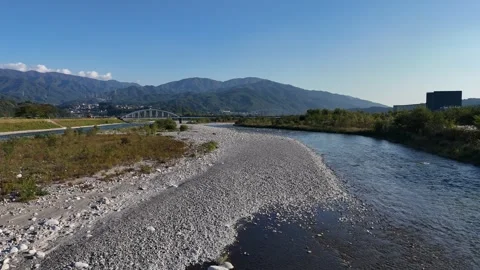 Broad Rocky Riverbed and Distant White Bridge Stock-Footage 347927764