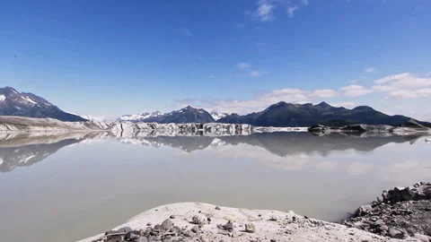 Broad view of glacial melt lake surrounded by mountains in Alaska Stock Footage 332186592