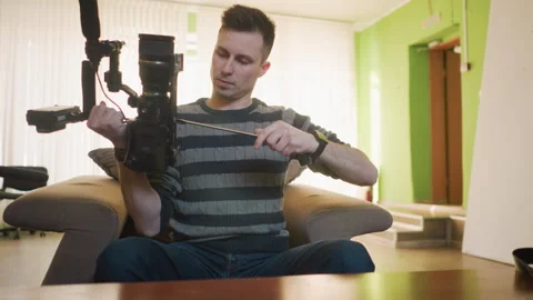 Broadcast director adjusting camera with microphone for filming Vídeo Stock 317586894