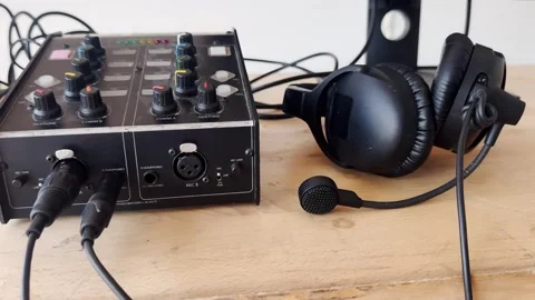 Broadcast intercom unit with connected cables and headset microphone on a Stockbeeldmateriaal 336406404