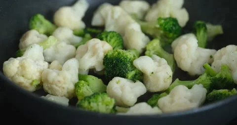 Broccoli and cauliflower cooking in a frying pan. Stock Footage 262782653