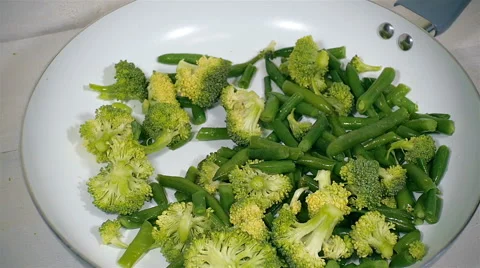 Broccoli and green beans fall into the pan. Slow motion. Stock Footage 57555338