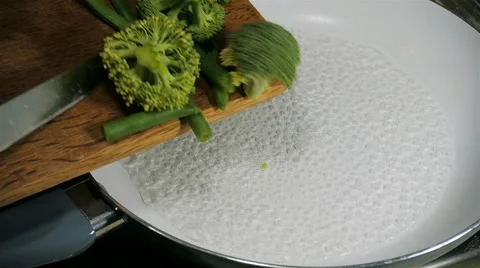 Broccoli and green beans fall into the pan. Slow motion. Stock Footage 57558016