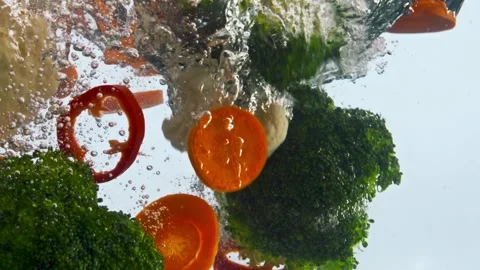 Broccoli and red pepper submerged in sparkling water Stock Footage 310743427