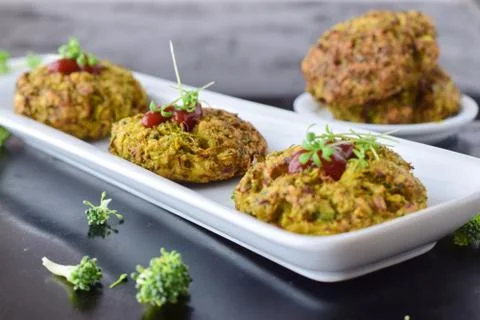 Broccoli balls deep fried on a white plate with tomato sauce, fresh broccoli Stock Photos