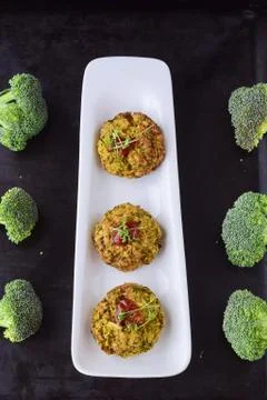 Broccoli balls deep fried on a white plate with tomato sauce, fresh broccoli Stock Photos
