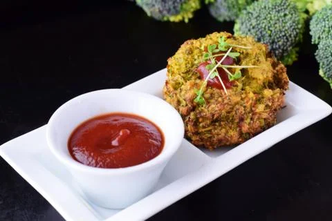 Broccoli balls deep fried on a white plate with tomato sauce, fresh broccoli Foto stock