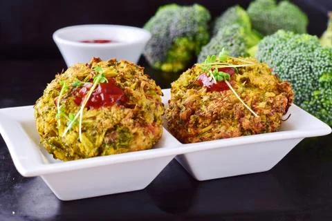 Broccoli balls deep fried on a white plate with tomato sauce, fresh broccoli Stock Photos