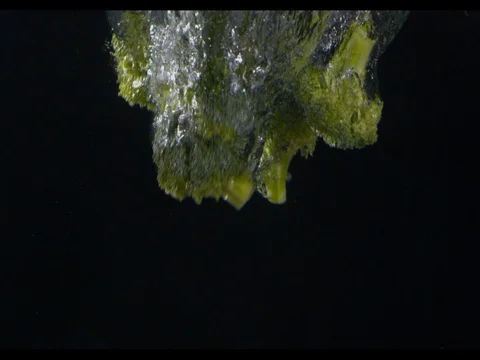 Broccoli diving into the water, black background, slow motion, m/s Stock Footage 74193234