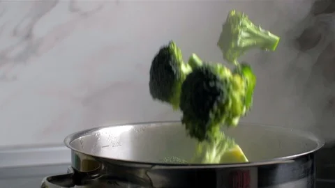Broccoli fall into a boiling pot of water. Slow motion Stock Footage 105345895